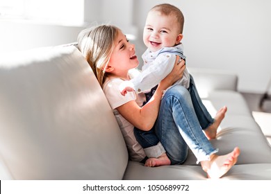 Little sister with her baby brother. Toddler kid Family with children at home. - Shutterstock ID 1050689972