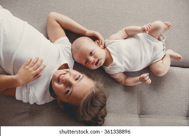 Little sister hugging her newborn brother. Toddler kid meeting new sibling. Cute girl and new born baby boy relax in a white bedroom. Family with children at home. Love, trust and tenderness - Powered by Shutterstock