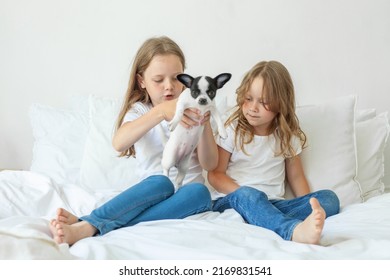 Little Sisters With Puppy Dog Pet Playing Together At Home