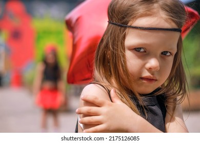 The Little Sisters Quarreled Over A Trifle. The Hippie Girl Stands With Her Hands Folded Busily With A Grin On Her Offended Face