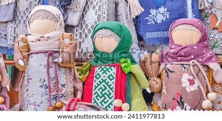 Little slavic folk rag dolls, closeup. Mascots associated with heathen traditions, amulets. Materials - cotton, linen, yarn, braid, wood. Handmade souvenirs or gifts on fair. Banner