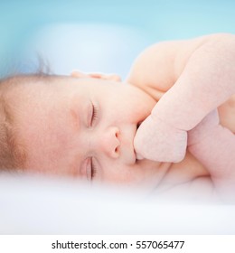 Little Sleepy Baby Lying On A White Bed 