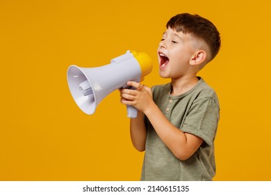 Little Small Boy 6-7 Years Old Wearing Green T-shirt Hold Scream In Megaphone Announces Discounts Sale Hurry Up Isolated On Plain Yellow Background Studio. Mother's Day Love Family Lifestyle Concept