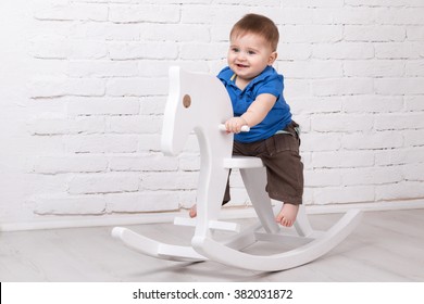 Little Smiling Baby Sitting On A White Horse, Wooden Rocking