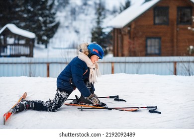 Little Smiling Boy Putting On Skis. Ski Equipment, Winter Clothes. Active Sports Entertainment During The Winter Holidays.