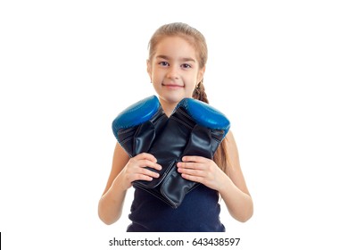 little smiling girl looking at the camera and holding a big boxing gloves