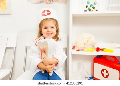 Little Smiling Girl Playing Dentist At The Cabinet