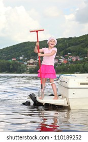 Little smiling girl stand on ladder of cutter hold mop in hands