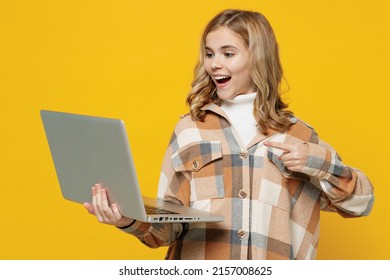 Little smiling happy fun blonde caucasian kid girl 13-14 years wearing checkered shirt hold use work point on laptop pc computer isolated on plain yellow background studio. People lifestyle concept. - Shutterstock ID 2157008625