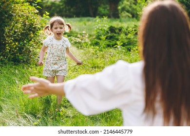 Little smiling happy kid girl 5-6 years old in white casual summer clothes runs towards mother play on park green sunshine lawn, spend time outdoor in village countyside during summer time vacations - Shutterstock ID 2146445779