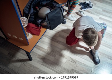 A little soccer player changing in a locker room after the game - Powered by Shutterstock