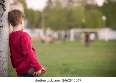 Little soccer player standing in the goalposts defending the the line and ready to throw a football. Cute kid boy standing as goalkeeper on a sportsfield on a sunny day. Sport activities for children - Powered by Shutterstock