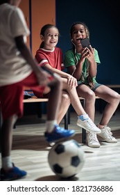 The Little Soccer Players Laughing At Cellphone Content In A Locker Room