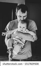 Little Son In Dad's Hands. Portrait Of Dad Kissing Baby Boy. Happy Father With His Son. Black And White Photo.