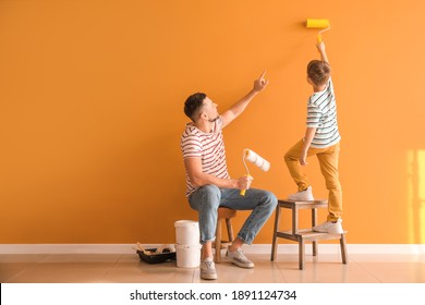 Little Son Helping His Father To Paint Wall At Home