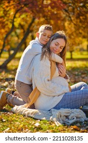 Little Son Hugs His Pregnant Mom On The Nature. Boy And Smiling Pregnant Woman Sitting In Autumn Park. Young Happy Family Waiting Baby. Pregnant Woman Enjoying Time With Her Child