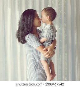 Little Son One Year Old Is Kissing His Happy Mother. Vintage Photo. Mom And Son Family Concept Idea.