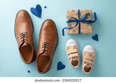 Little son showing love on Father's Day. Top view of leather shoes, baby sneakers, hearts, and craft paper giftbox with ribbon bow on pastel blue background - Powered by Shutterstock