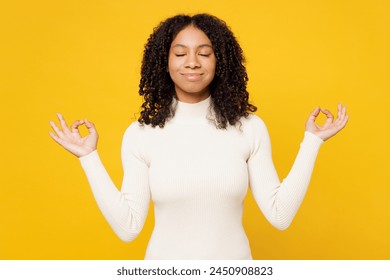 Little spiritual kid teen girl wear white casual clothes hold spreading hands in yoga om aum gesture relax meditate try to calm down isolated on plain yellow background. Childhood lifestyle concept - Powered by Shutterstock