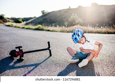 Little Sport Kid Holding His Knee Suffering From Pain After Road Accident Scooter