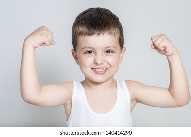 Little Strong Boy Playing With Muscles And Smiling