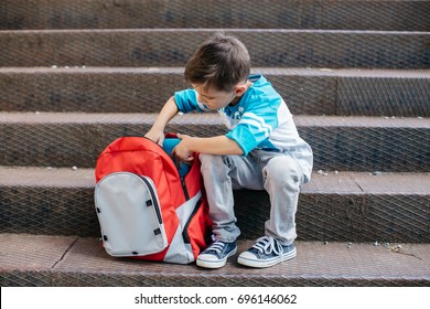 Little Student On His First Day Of School Checking Books Inside His Backpack 