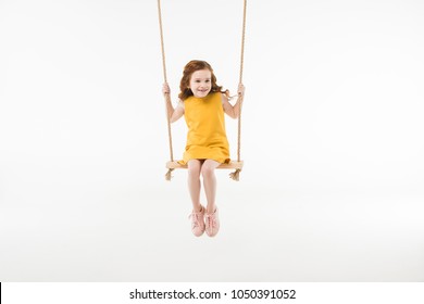 Little stylish child in dress riding on swing isolated on white - Shutterstock ID 1050391052