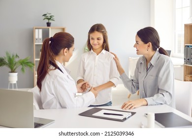 Little teen girl during medical examination receives support from her mother and friendly female pediatrician. Doctor holds child's hands and mother touches shoulder, assuring that everything is fine. - Powered by Shutterstock