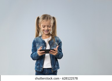 Little Teenage Girl Using Cell Smart Phone, Small Kid Happy Smiling Child Isolated Over Gray Background