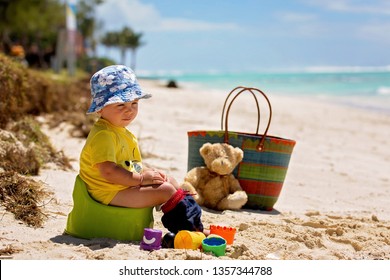 Little toddler boy, learning potty training on the beach on a tropical island Mauritius