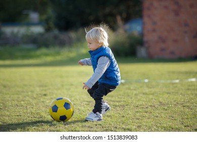 Little Toddler Boy, Playing With Soccer Ball On Playground In The Park, Autumn Sunny Day