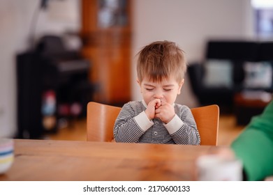 Little Toddler Boy Sitting At Wooden Table Sadly Looking Sideways