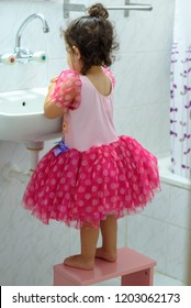  Little Toddler Girl In Dress Stand On Kids Wood Chair In Bathroom. Cute Child Washing Hand With Water And Soap.Prevent Flu: To Keep The Flu Virus At Bay, Wash  Hands With Soap And Water Several Times