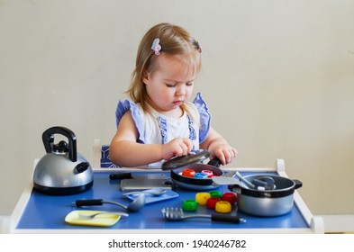 Little Toddler Girl Having Fun Playing Alone With Cooking Toys, Kitchen Set And Natural Materials - Beans,  Macaroni. Games With Products. Educational, Sensory And Role Play Toys For Young Kid Concept