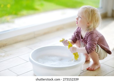 Little Toddler Girl Helping Her Mom To Clean Up On Spring Day