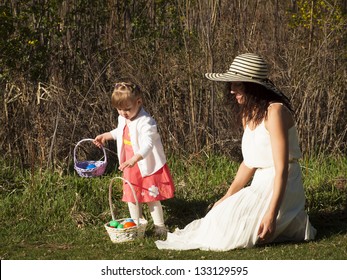 Little Toddler Girl On Easter Egg Hunt In Urban Park.