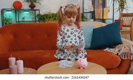 Little Toddler Kid Girl Counting Money Dollar Banknotes At Home Desk With Piggybank. School Teen Children Save Money, Pocket Cash For Future Needs, Education, Purchases, Learn, Economy From Childhood