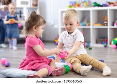Little toddlers boy and a girl play together in nursery room. Preschool children in day care centre