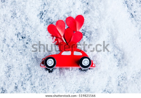 Little toy car\
with heart shape symbol on\
snow