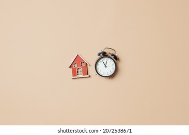 Little Toy House And Alarm Clock On Stark White Background. Above View