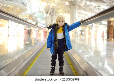 Little Traveler On A High-speed Sidewalk At An International Airport. Family Trip For Winter Holidays. Kids Vacations. Relocation To Another Country