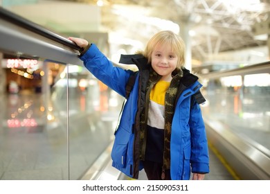 Little Traveler On A High-speed Sidewalk At An International Airport. Family Trip For Winter Holidays. Kids Vacations. Relocation To Another Country