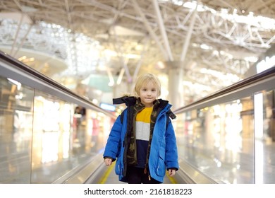 Little Traveler On A High-speed Sidewalk At An International Airport. Family Trip For Winter Holidays. Kids Vacations. Relocation To Another Country