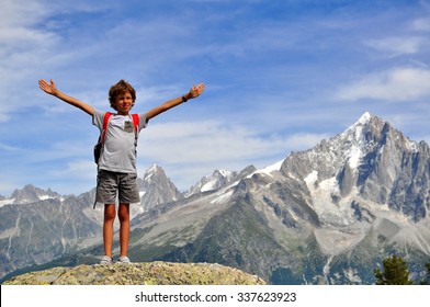 Little traveller at the top in french Alps. Hiking in mountains on summer