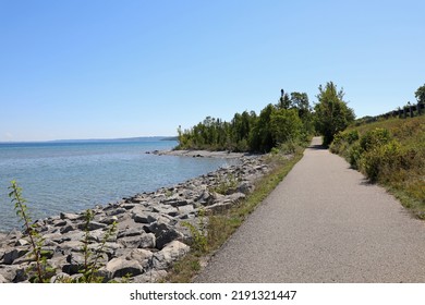 Little Traverse Wheelway is a picturesque paved trail running parallel to the Route 31. The 26-mile path stretches from Charlevoix to Petoskey to Harbor Springs, in Northern Michigan. - Shutterstock ID 2191321447