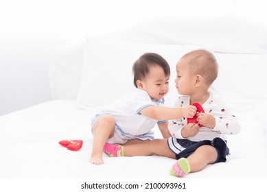 Little Two Asian Baby Girls Plaing Together At Home.