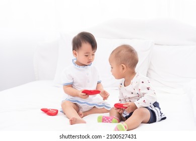 Little Two Asian Baby Girls Plaing Together At Home.