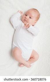 Little Two-month Baby Boy In White Romper On A White Textile Background