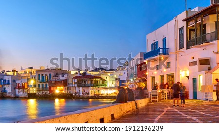The Little Venice district with bars and restaurants by the sea in Mykonos island at dusk, Greece. Greek resort at night