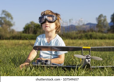 The little villain kid and his new RC plane, outdoors on grass